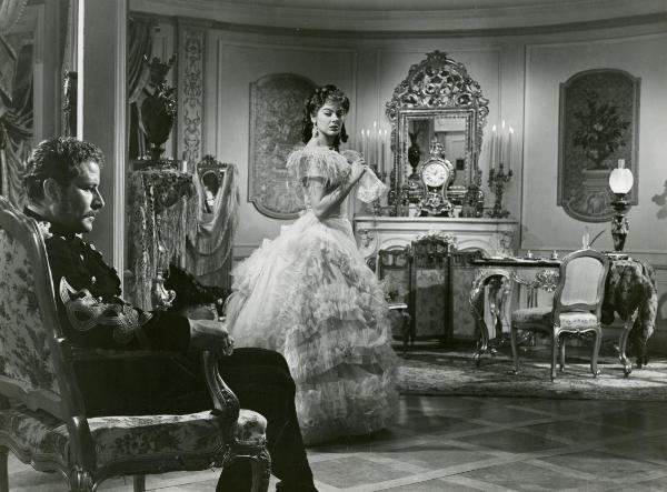 Scena del film "La fiammata" - Blasetti, Alessandro, 1952 - Eleonora Rossi Drago, a destra in secondo piano con un fazzoletto in mano, osserva Amedeo Nazzari, a sinistra in primo piano in vesti militari che guarda dritto davanti a sé.
