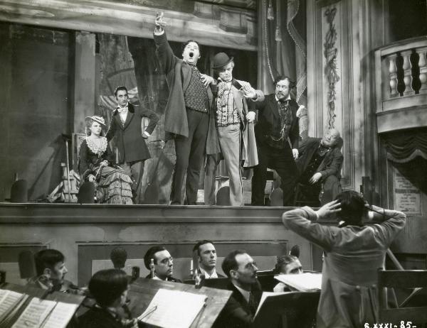 Scena del film "Figaro e la sua gran giornata" - Camerini, Mario, 1931 - Giachetti, al centro, fa segno di fermarsi e viene trattenuto da un attore non identificato a destra. In secondo piano, Leda Gloria e Maurizio D'Ancora osservano la scena.