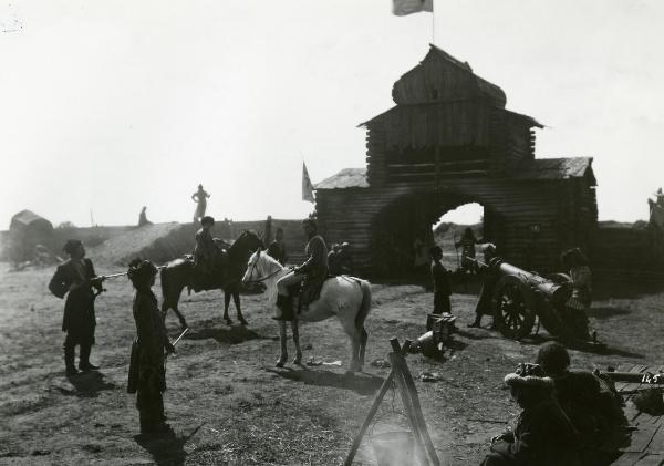 Scena del film "La figlia del capitano" - Camerini, Mario, 1947 - Due attori non identificati a sinistra in piedi, tengono sotto tiro due attori non identificati a cavallo, al centro, che guardano verso l'obbiettivo. Intorno, attori non identificati.