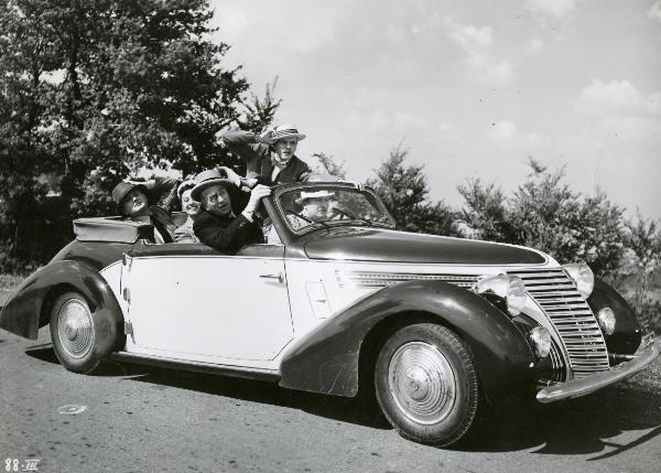 Scena del film "I figli del Marchese Lucera" - Palermi, Amleto, 1938 - In un'autovettura: Carlo Romano, alla guida, Armando Falconi, al suo fianco, Sergio Tofano, in piedi, Filippo Scelzo, dietro con una mano sul cappello. Al centro, Clelia Matania.