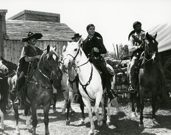 Scena del film "Un fiume di dollari" - Lizzani, Carlo, 1966 - Henry Silva, a cavallo circondato da altri attori non identificati a cavallo e armati, guarda verso destra.
