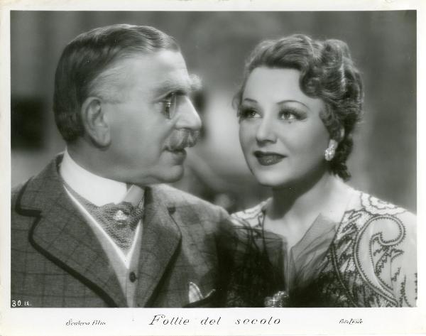 Scena del film "Follie del secolo" - Palermi, Amleto, 1939 - Primo piano di Armando Falconi rivolto verso destra mentre osserva e parla con Paola Barbara che guarda dritto davanti a sé.
