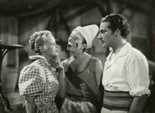 Scena del film "La forza bruta" - Bragaglia, Carlo Ludovico, 1941 - Al centro, Claudio Ermelli tiene per il mento Maria Mercader mentre sorride. A destra, Rossano Brazzi li osserva.
