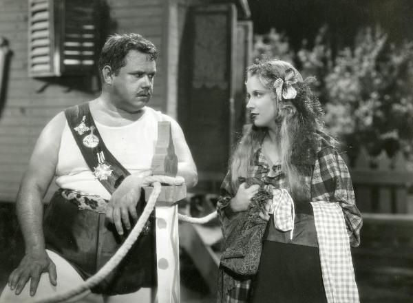 Scena del film "La forza bruta" - Bragaglia, Carlo Ludovico, 1941 - Juan De Landa, a sinistra, seduto e appoggiato alla balaustra guarda Maria Mercader, a destra, che lo fissa a sua volta con in mano degli stracci.
