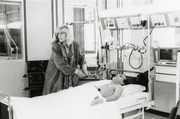 Scena del film "Francesca è mia" - Russo, Roberto, 1986 - Monica Vitti al fianco del letto di ospedale su cui è sdraiato Pierre Malet intubato, mentre cerca di armeggiare con i fili per la rianimazione.
