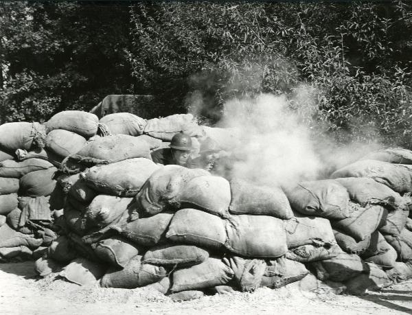 Scena del film "Fraulein doktor" - Lattuada, Alberto, 1969 - Dietro una muraglia fatta di sacchi, due attori non identificati in veste di soldati, stanno sparando.