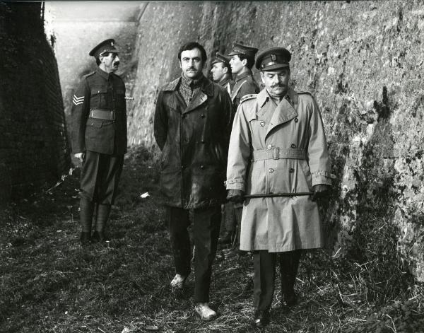 Scena del film "Fraulein doktor" - Lattuada, Alberto, 1969 - In primo piano Kenneth More tiene tra le mani un bastone. Al suo fianco, James Booth guarda di fronte a sé. Dietro, tre attori non identificati nei panni di militari.