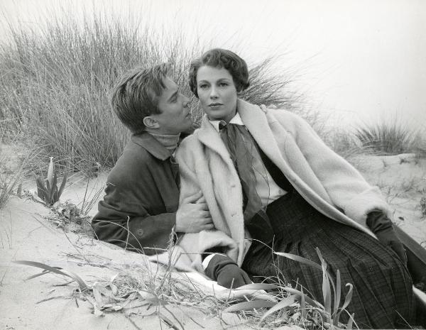 Scena del film "Frou - Frou" - Genina, Augusto, 1955 - Sdraiati in mezzo a degli arbusti, Philippe Lemaire tiene per il braccio e per la spalla Dany Robin e le sussura all'orecchio. L'attrice sdraiata su di lui, guarda davanti a sé.