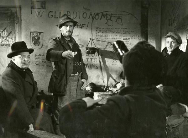 Scena del film "Fuga in Francia" - Soldati, Mario, 1948 - All'interno di una stanza, da sinistra a destra: Folco Lulli, Enrico Olivieri e Pietro Germi guardano verso un attore non identificato di spalle in primo piano.