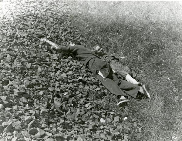 Scena del film "Fumeria d'oppio" - Matarazzo, Raffaello, 1947 - Stesi al suolo tra pietre e arbusti, un attore non identificato a sinistra e Mariella Lotti a destra sono malridotti.