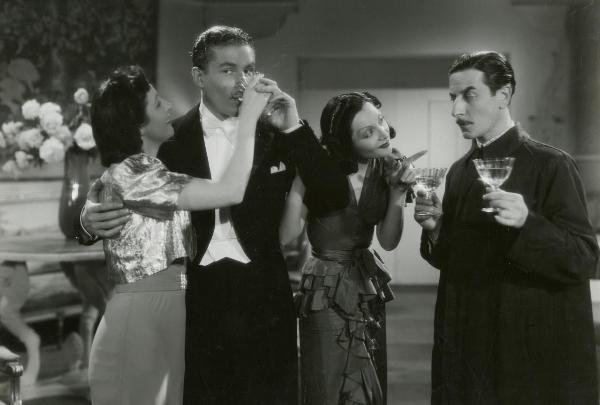 Scena del film "Fuochi d'artificio" - Righelli, Gennaro, 1938 - Da sinistra a destra: Italia Volpiani regge un bicchiere alla bocca di Amedeo Nazzari; Anna Valpreda, si appoggia al braccio sinistro di Nazzari mentre indica Giuseppe Porelli.