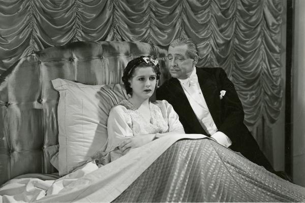 Scena del film "Fuochi d'artificio" - Righelli, Gennaro, 1938 - Su un letto a braccia conserte, Vanna Vanni. Di fianco a lei, Luigi Carini la osserva.