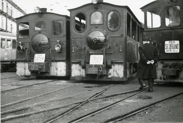 Scena del film "Gamba de legn" - Guerrasio, Guido, 1952 - In una stazione, tre vagoni posizionati l'uno accanto all'altro sulle rotaie. A destra, un attore non identificato di spalle.