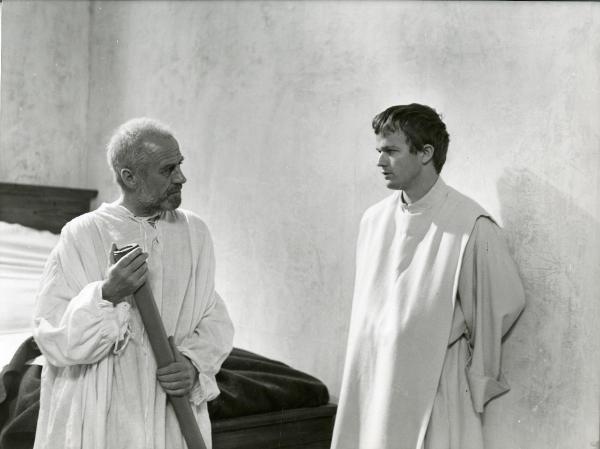 Scena del film "Galileo" - Cavani, Liliana, 1968 - In una stanza, Lou Castel, a destra, e Cyril Cusack, a sinistra, si guardano. Entrambi sono in vesti sacerdotali.