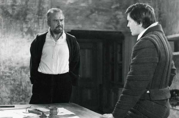 Scena del film "Galileo" - Cavani, Liliana, 1968 - Attorno a una scrivania: a sinistra, Cyril Cusack guarda verso un attore non identificato di profilo posizionato a destra.