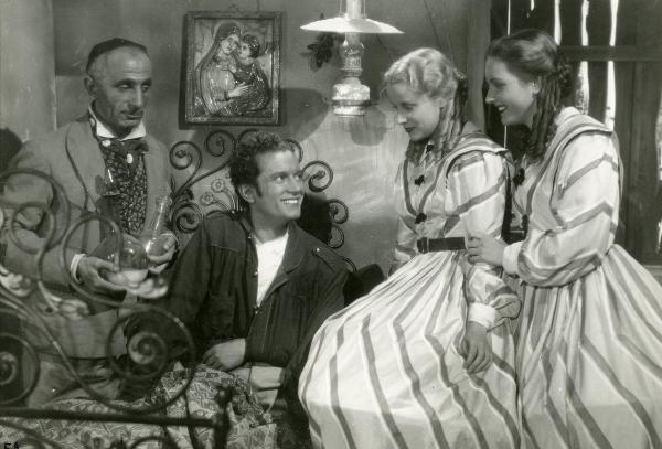 Scena del film "Un garibaldino al convento" - De Sica, Vittorio, 1942 - A destra, Carla Del Poggio e Marìa Mercander, guardano Leonardo Cortese seduto su un letto. A sinistra, Fausto Guerzoni guarda la scena tenendo in mano delle ampolle.