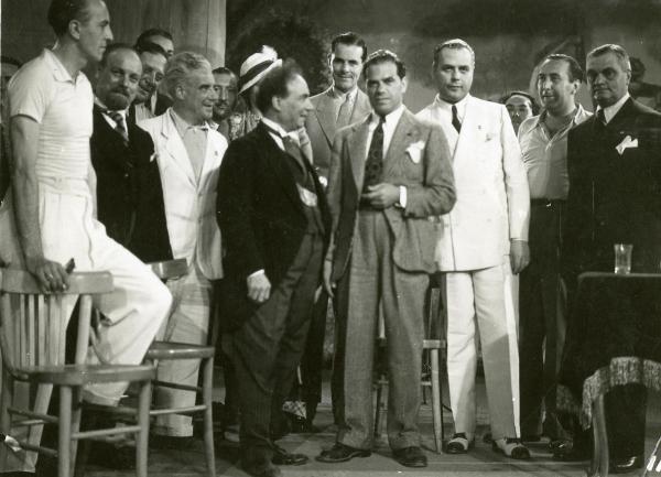 Scena del film "Gatta ci cova" - Righelli, Gennaro, 1937 - In fila molti attori non identificati. Al centro, si riconosce Angelo Musco di profilo.