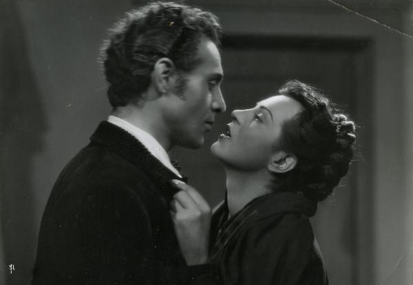 Scena del film "Gelosia" - Poggioli, Ferdinando Maria, 1943 - Primo piano di Luisa Ferida e Roldano Lupi mentre si stanno per scambiare un bacio e si guardano negli occhi.