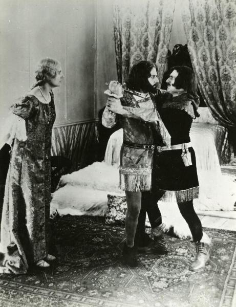 Scena del film "Genoeffa di Brabante" - Zeglio, Primo, 1947 - In una stanza da letto: un attore non identificato trattiene per le braccia un altro attore non identificato mentre tiene in mano un pugnale. A sinistra, Harriet Medin guarda la scena.