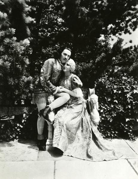 Scena del film "Genoeffa di Brabante" - Zeglio, Primo, 1947 - In un cortile, Harriet Medin e Gar Moore si abbracciano seduti l'uno vicino all'altra.