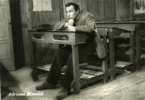 Scena del film "Gente così" - Cerchio, Fernando, 1949 - Seduto in un banco di scuola, Adriano Rimoldi guarda davanti a sé con la testa appoggiata alle sue mani.