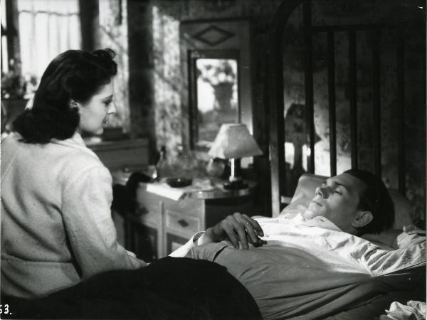 Scena del film "Germania anno zero" - Rosselini, Roberto, 1948 - In una stanza da letto: Franz Krüger disteso sul letto con una sigaretta nella mano destra guarda un'attrice non identificata seduta davanti a lui.