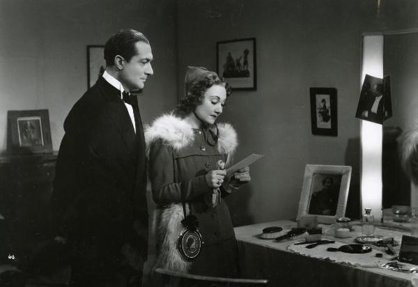 Scena del film "Gioco pericoloso" - Malasomma, Nunzio, 1942 - In un camerino di prova: a destra, Elsa Merlini, tenendo in mano una fotografia, la guarda. A sinistra, Nerio Bernardi guarda la Merlini.