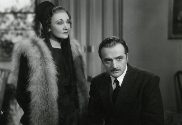 Scena del film "Gioco pericoloso" - Malasomma, Nunzio, 1942 - Elsa Merlini, a sinistra, guarda dritto davanti a sé. A destra, Renato Cialente guarda di fronte a lui, assorto.