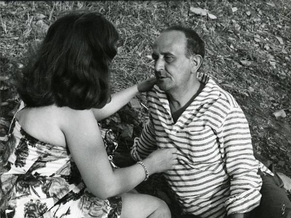 Scena del film "I giorni contati" - Petri, Elio, 1962 - Semidistesi su un prato: un'attrice non identificata, a sinistra, mentre tende le braccia verso Salvo Randone, a destra.