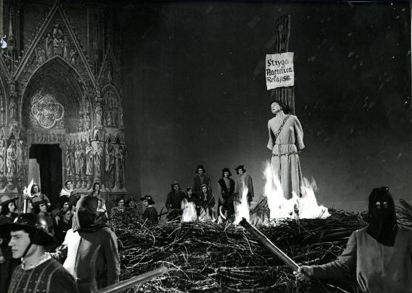 Scena del film "Giovanna d'Arco al rogo" - Rossellini, Roberto, 1954 - Sul piazzale di una cattedrale, l'attrice Ingrid Bergman viene bruciata sul rogo. Attorno, una folla di attori non identificati.