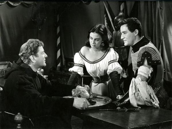 Scena del film "Giovanni dalle bande nere" - Grieco, Sergio, 1956 - Da sinistra a destra: Philippe Hersent, Anna Maria Ferrero e Vittorio Gassman. Gassman e la Ferrero guardano Hersent che tra le mani tiene un vassoio con un pollo.