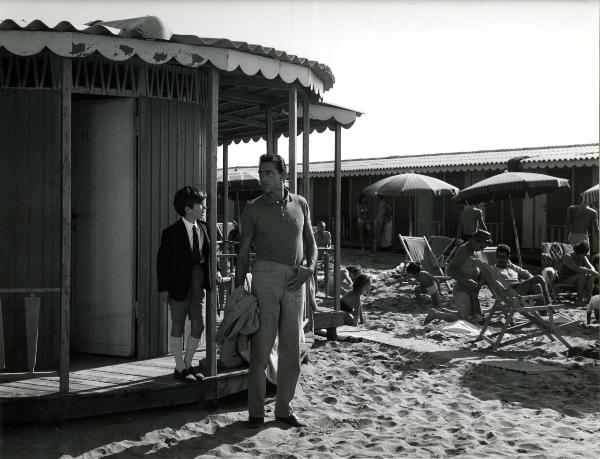 Scena del film "Il giovedì" - Risi, Dino, 1964 - In spiaggia, sotto il gazebo degli spogliatoi, Roberto Ciccolini parla a Walter Chiari che, nel mentre, lo ascolta. Attorno, attori non identificati.