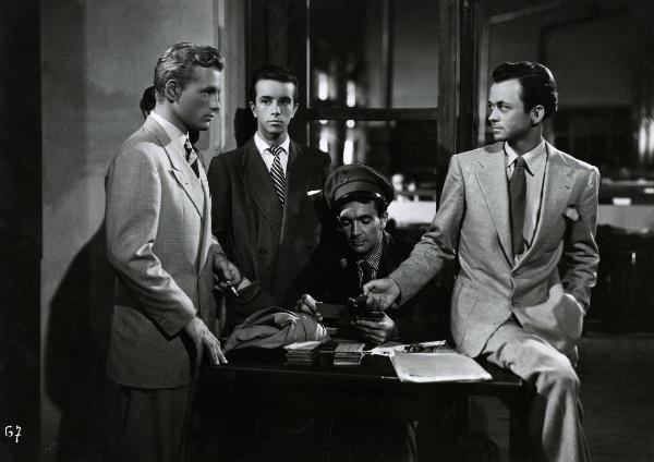 Scena del film "Gioventù perduta" - Germi, Pietro, 1947 - Da sinistra a destra: Jacques Sernas, un attore non identificato, Massimo Girotti e un altro attore non identificato. I due attori non identificati guardano Sernas che ricambia lo sguardo.