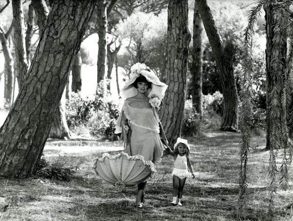 Scena del film "Giulietta degli spiriti" - Fellini, Federico, 1965 - In mezzo a un bosco, Sylva Koscina tiene con la mano destra un ombrello mentre con la sinistra tiene per mano una bambina non identificata.







