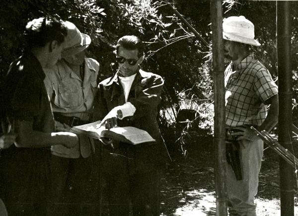 Sul set del film "Giungla" - Malasomma, Nunzio, 1942 - Al centro, il regista Nunzio Malasomma mentre dà indicazioni ad alcuni collaboratori non identificati attorno a lui.




