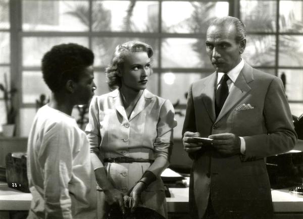 Scena del film "Giungla" - Malasomma, Nunzio, 1942 - Da destra a sinistra: Mario Ferrari, Vivi Gioi e Louis Brody. Gli attori si scambiano degli sguardi.


