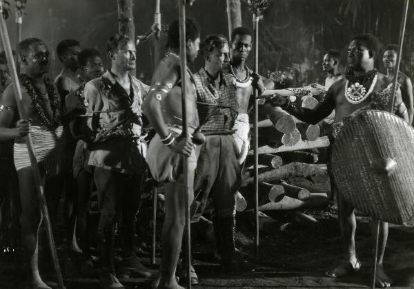 Scena del film "Giungla" - Malasomma, Nunzio, 1942 - Catturati e legati da una tribù indigena: Rodolfo Fernau, a sinistra, e Albrecht Schönhals, a destra, guardano il capo tribù.



