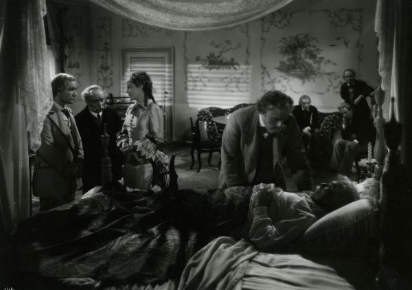 Scena del film "Giuseppe Verdi" - Gallone, Carmine, 1938 - In una stanza, un attore non identificato è steso su un letto. Vicino a lui, Fosco Giachetti. Dietro, Maria Cebotari con due attori non identificati.


