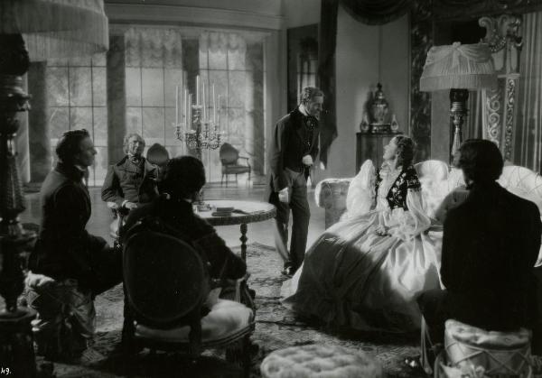 Scena del film "Giuseppe Verdi" - Gallone, Carmine, 1938 - In un salotto, attorno a un tavolino, alcuni attori non identificati.