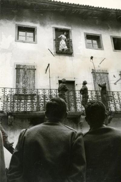 Sul set del film "La grande guerra" - Monicelli, Mario, 1959 - Affacciata a un balcone, Silvana Mangano. Sotto, operatori non identificati riprendono la scena.



