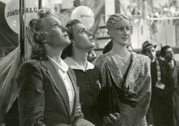 Scena del film "Grandi magazzini" - Camerini, Mario, 1939 - Da sinistra a destra: Assia Noris e Luisella Beghi mentre guardano in alto. Vicino a loro un manichino.
