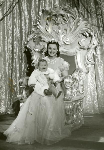 Scena del film "La Granduchessa si diverte" - Gentilomo, Giacomo, 1940 - In abito da sera, seduta su un trono, Paola Barbara tiene in braccio un bambino.


