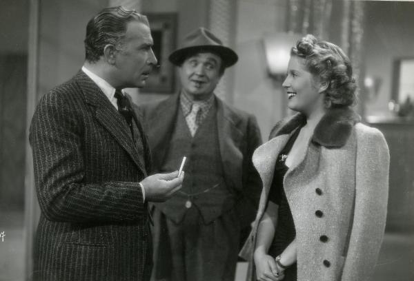 Scena del film "Grattacieli" - Giannini, Guglielmo, 1943 - Mezza figura di Luigi Pavese a sinistra e Vanna Vanni a destra. I due si guardano negli occhi. Dietro, un attore non identificato.

