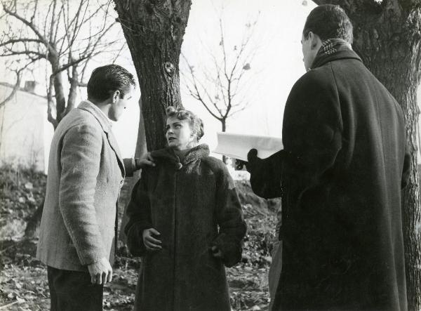 Sul set del film "Il grido" - Antonioni, Michelangelo, 1957 - In mezzo ad alcuni alberi: a destra di spalle, il regista Michelangelo Antonioni con in mano il copione. A sinistra, Steve Cochran e Alida Valli mentre si guardano negli occhi.










