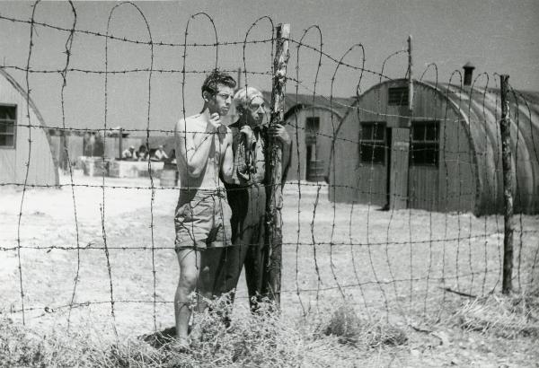 Scena del film "Il grido della terra" - Coletti, Duilio, 1948 - Dietro un recinto in filo spinato, due attori non identificati.