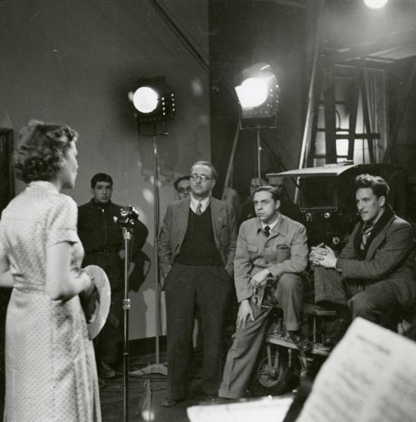 Sul set del film "Idillio a Budapest" - Ansoldi, Giorgio, Varriale, Gabriele, 1941 - I registi Gabriele Varriale, a sinistra e Giorgio Ansoldi, a destra. Di fianco a loro seduto l'aiuto regista Aldo De Lisi. A sinistra, Germaine Aussey sta provando.