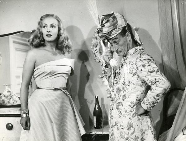 Scena del film "L'imperatore di Capri" - Comencini, Luigi, 1949 - Mezza figura di Totò, a destra e Yvonne Sanson, a sinistra. Tutti e due gli attori guardano nella stessa direzione e Totò tiene in mano la cornetta di un telefono.



