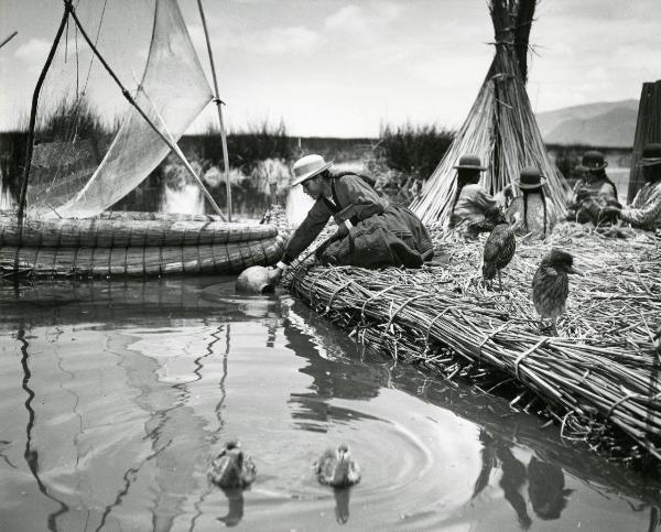 Scena del film "L'impero del sole" - Craveri, Mario, Gras, Enrico, Moser, 1956 - Sulla riva di un fiume, un'attrice non identificata raccoglie dell'acqua con una giara. Dietro, alcune attrici non identificate intrecciano delle canne di bambù.
