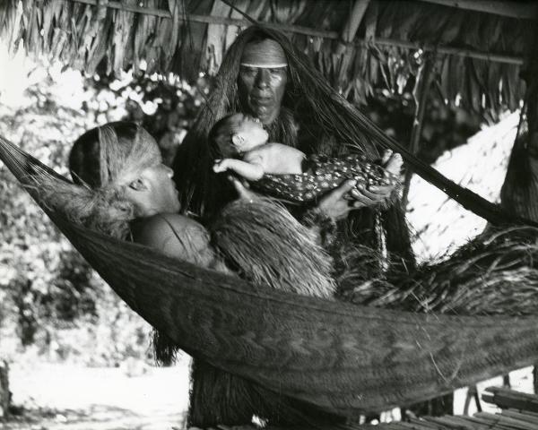 Scena del film "L'impero del sole" - Craveri, Mario, Gras, Enrico, Moser, Giorgio, 1956 - Una madre sdraiata su un'amaca, riceve il figlio per la prima volta tra le braccia dallo sciamano.



