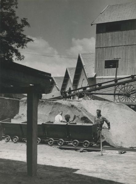 Roma - Quartiere del tuscolano - Montecatini - Stabilimento prodotti chimici per l'agricoltura - Impianto solforico - Carico pirite - Carrelli - Operai